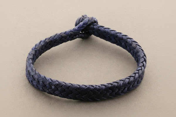 Navy blue braided bracelet on a light gray background