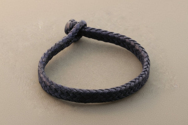 Navy blue braided bracelet on a light gray background