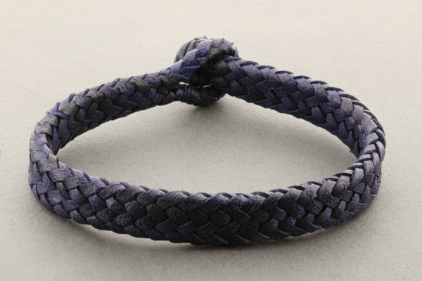 Navy blue braided bracelet on a light gray background