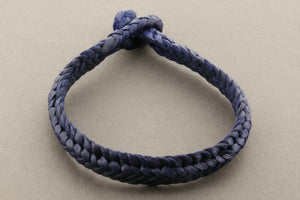 Navy blue braided bracelet on a light gray background