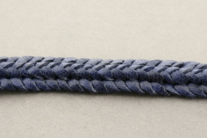 Close-up of a blue braided rope on a gray background