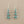 Load image into Gallery viewer, Pair of silver earrings with turquoise stones on a gray background