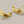 Load image into Gallery viewer, Pair of gold branch-like earrings on a gray background