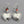 Load image into Gallery viewer, Silver heart-shaped earrings with red beads on a gray background