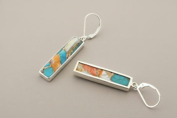 Pair of earrings with rectangular stone inlay on a gray background
