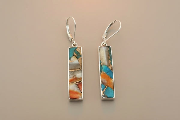 Pair of earrings with rectangular multicolored stones on a gray background