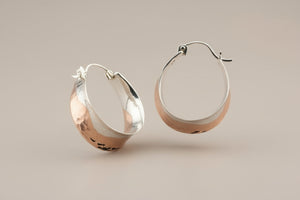 Pair of silver hoop earrings on a gray background