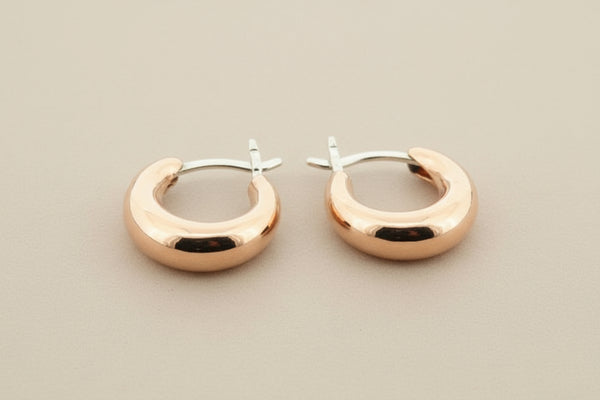 Copper & silver hoop earrings on a gray background
