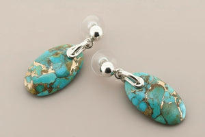Turquoise stone earrings with silver posts on a gray background