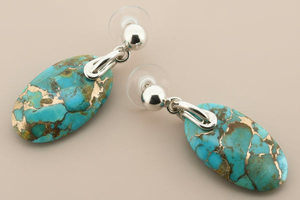 Turquoise stone earrings with silver posts on a gray background