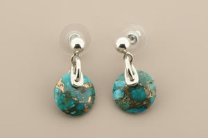 Pair of turquoise earrings with silver hooks on a gray background