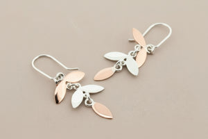 Pair of leaf-shaped earrings on a gray background