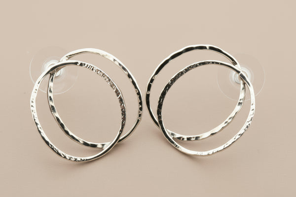 Pair of silver hoop earrings on a gray background