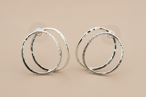 Pair of silver hoop earrings on a gray background