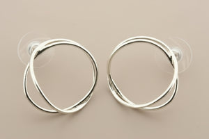 Pair of silver hoop earrings on a gray background