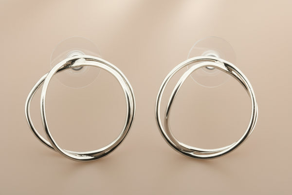 Pair of silver hoop earrings on a gray background
