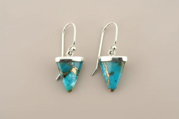 Turquoise triangle earrings with silver hooks on a gray background