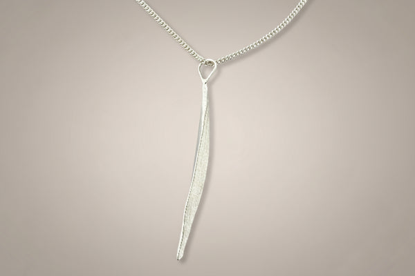 Silver necklace with a unique pendant on a gray background