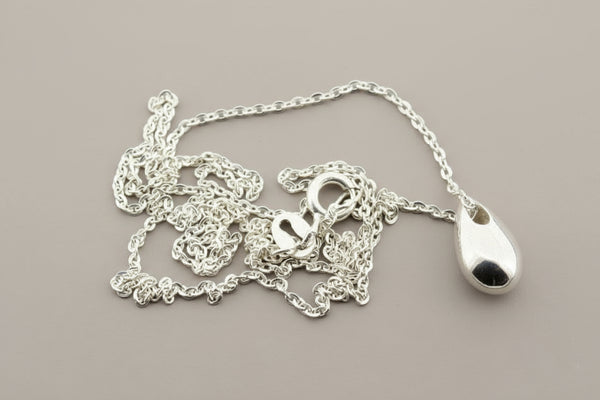 Silver necklace with a teardrop pendant on a gray background