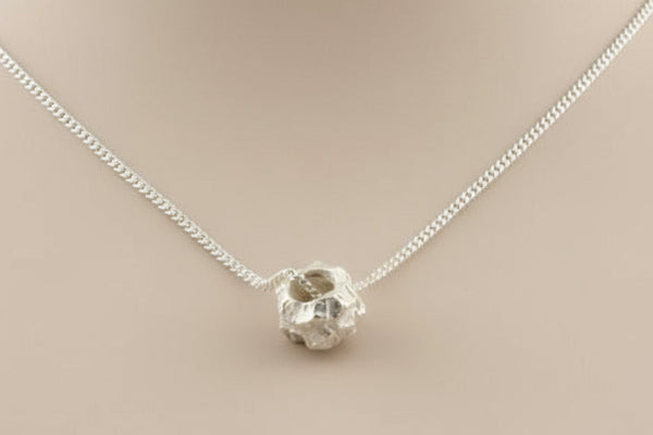 Silver necklace with a unique pendant on a gray background