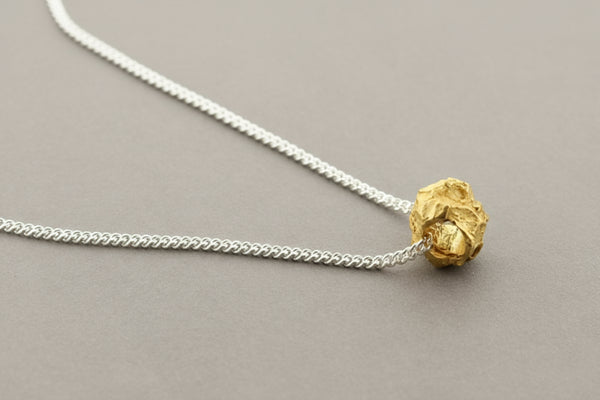 Necklace with a gold pendant on a gray background