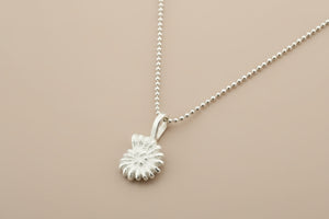 Silver necklace with a detailed pendant on a gray background