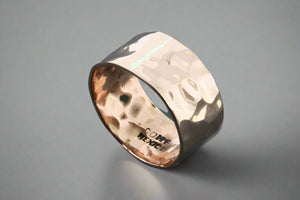 Copper ring with a textured band on a dark grey background