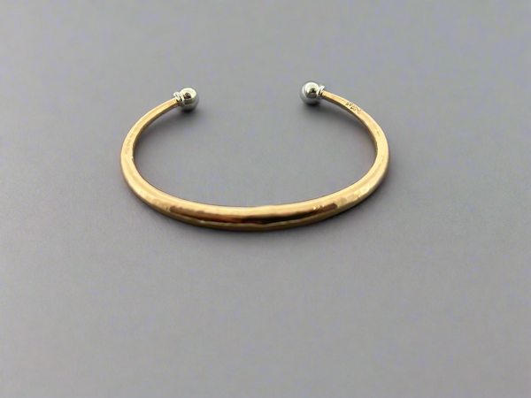 Gold bracelet on a dark gray background