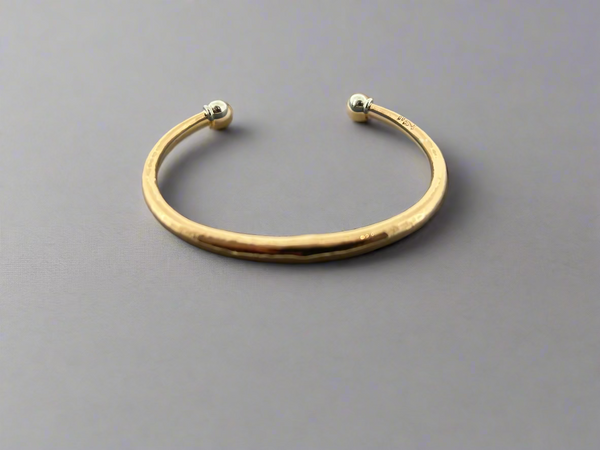 Bronze bracelet with silver beads on a dark gray background