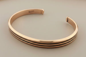 Rose gold bangle on a gray background