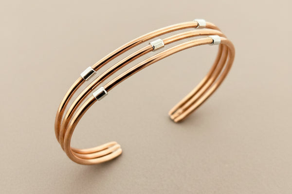 Rose gold bracelet on a dark gray background