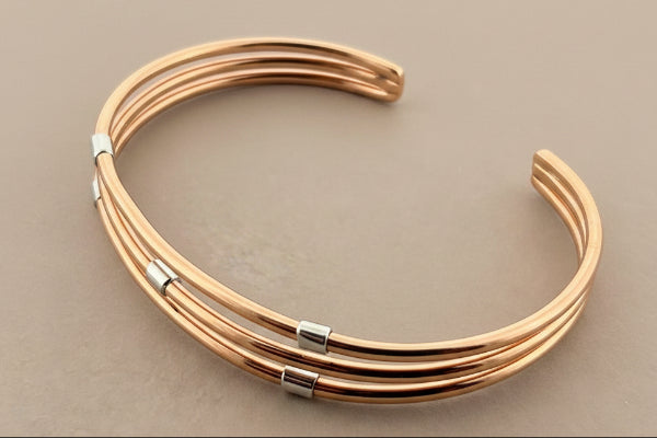 Rose gold bracelet on a dark gray background