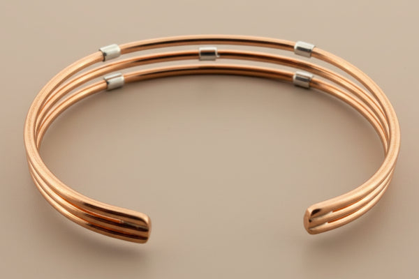 Rose gold bracelet on a dark gray background