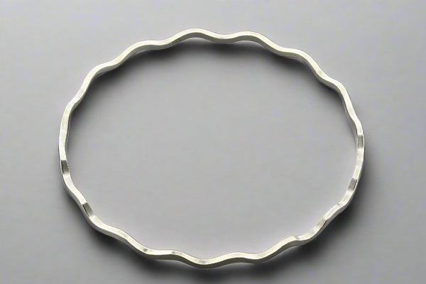 Silver bracelet on a gray background