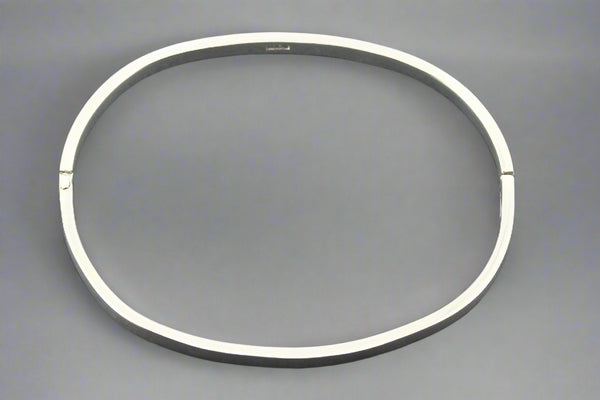 Silver bangle on a gray background