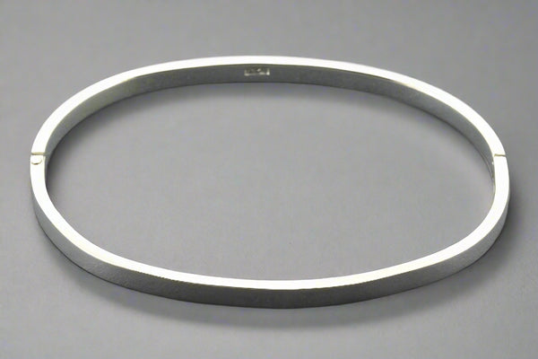 Silver bangle on a gray background