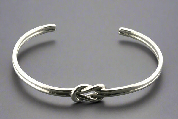Silver knot bracelet on a gray background
