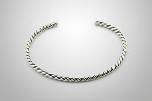 Silver twisted bangle on a gray background