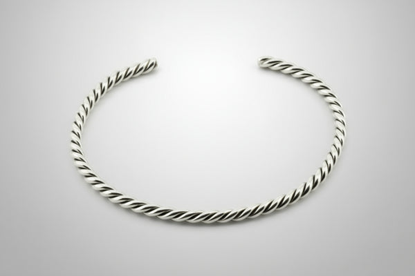 Silver twisted bangle on a gray background