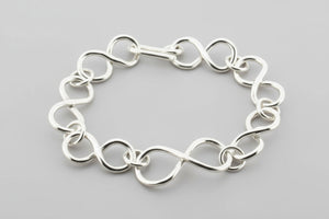 Silver chain bracelet on a dark gray background