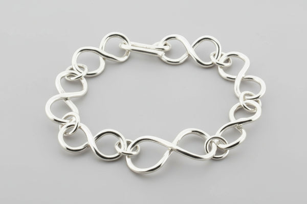 Silver chain bracelet on a dark gray background