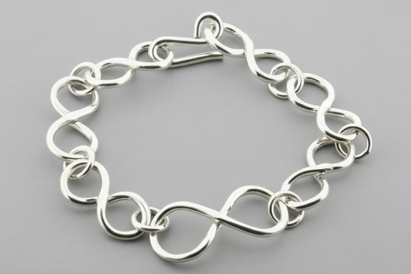 Silver chain bracelet on a gray background