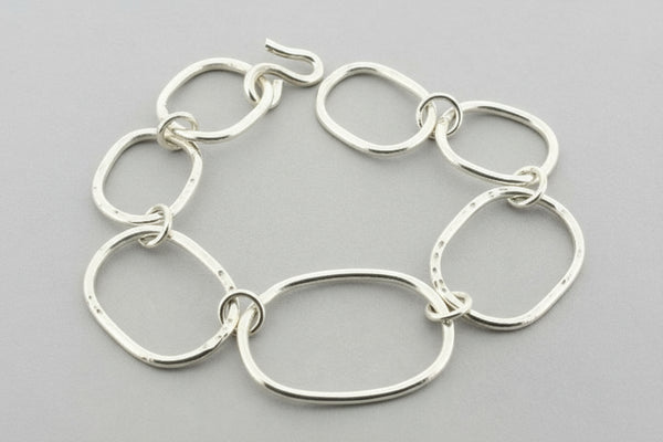 Silver chain bracelet on a dark gray background