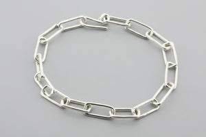 Silver chain bracelet on a gray background