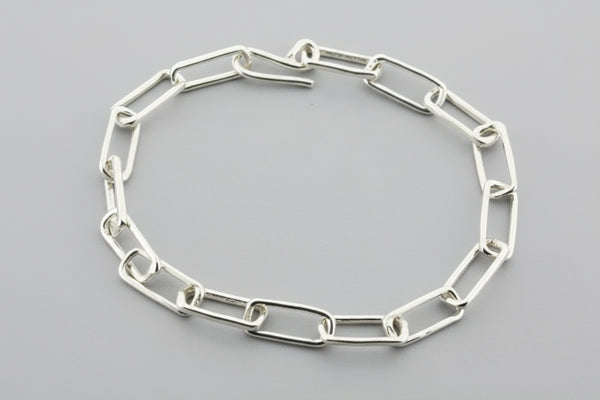 Silver chain bracelet on a gray background
