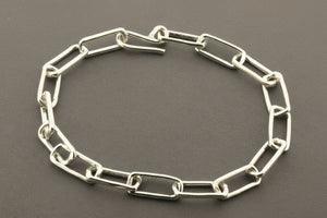 Silver chain bracelet on a gray background