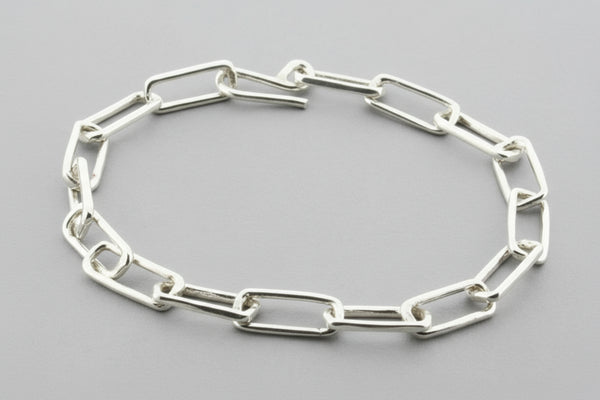 Silver chain bracelet on a gray background