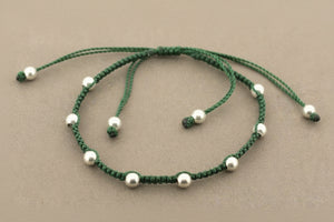 Green beaded necklace on a gray background