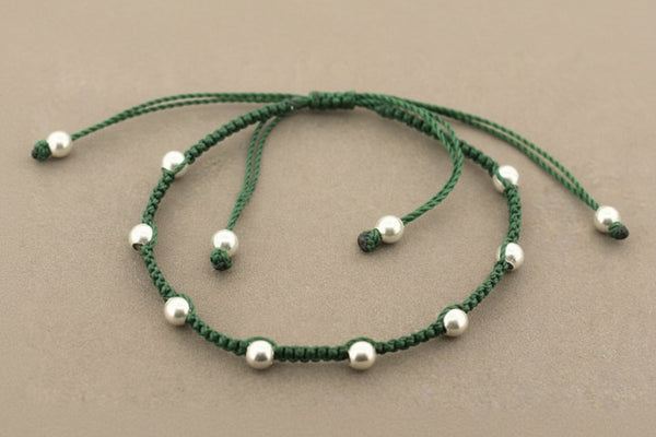 Green beaded necklace on a gray background