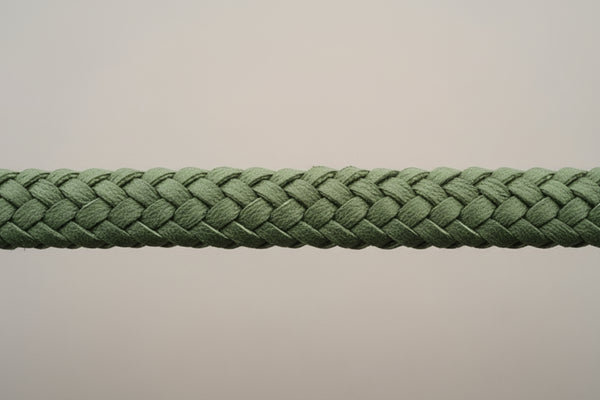 Close-up of a green braided rope on a gray background